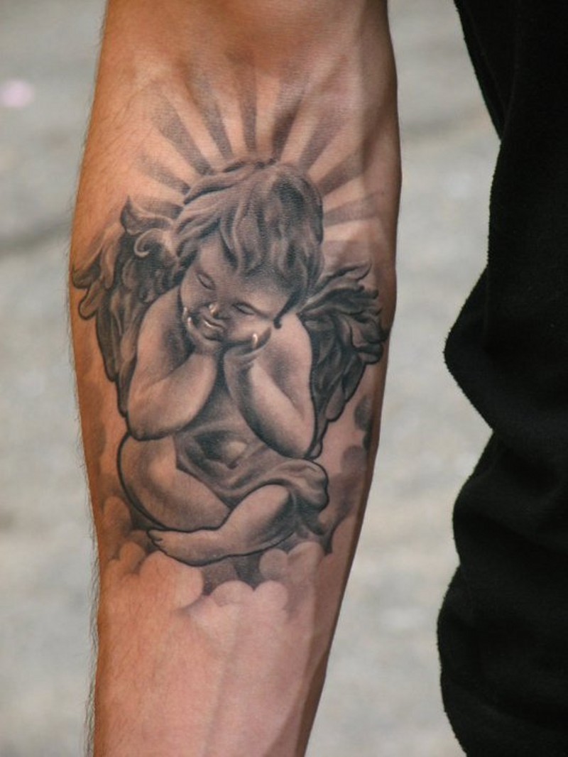 Kleiner Engel sitzt auf Wolke Tattoo am Arm