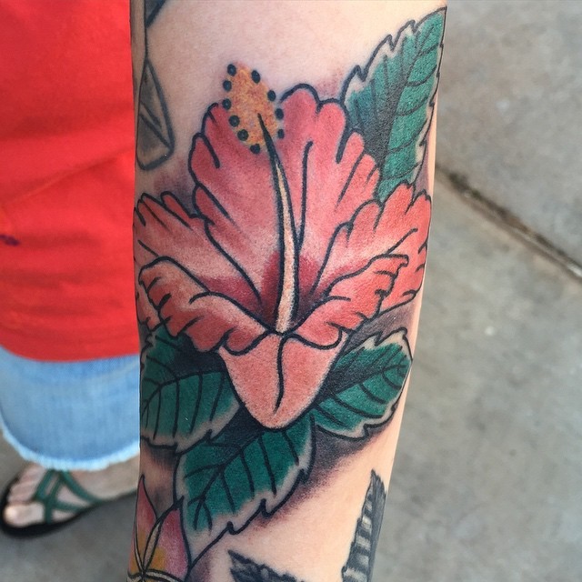 Blasse rote Hibiskusblüte Tattoo am Unterarm im Oldschool Stil